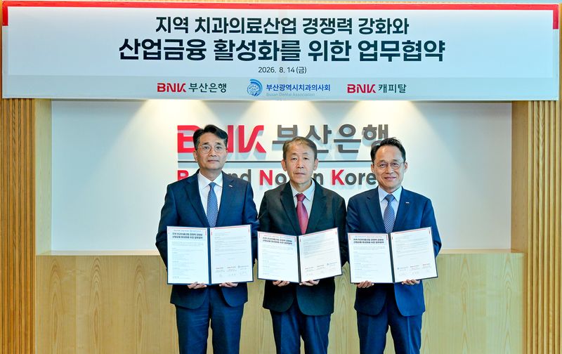 BNK부산은행 김영준 기업고객그룹장(왼쪽부터)과 부산광역시치과의사회 조수현 회장, BNK캐피탈 오성호 경영전략본부장이 협약서를 들고 포즈를 취하고 있다. BNK부산은행 제공