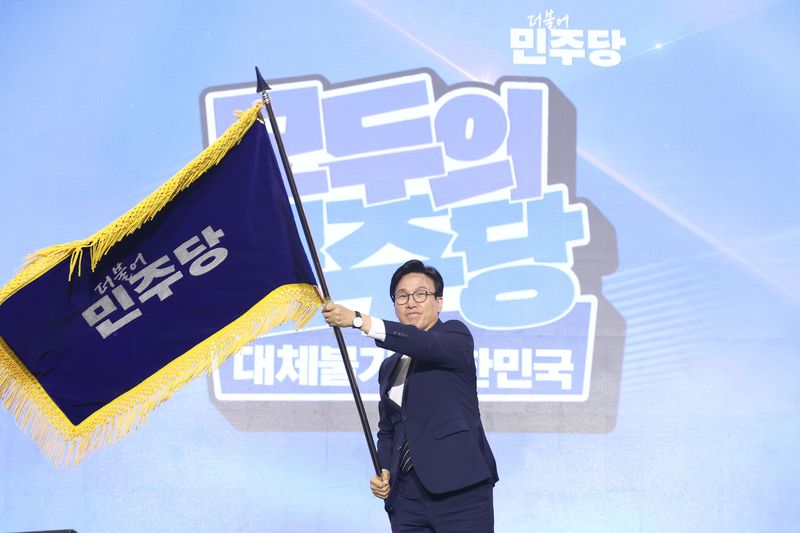 김민석 신임 더불어민주당 당대표가 17일 대전 유성구 대전컨벤션센터 제2전시장에서 열린 더불어민주당 제3차 정기전국당원대회에서 당기를 흔들고 있다. 뉴시스