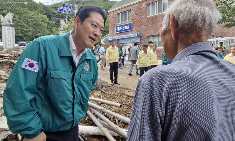 장동혁 국민의힘 대표가 18일 극한 호우로 피해를 입은 경남 통영시 봉평동 용화사 인근 한 도로를 점검하며 주민과 대화하고 있다. 뉴스1