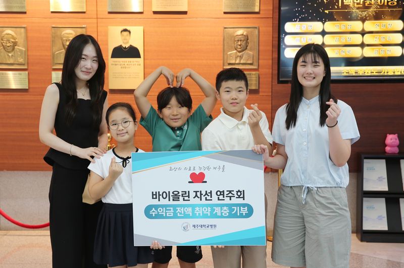 제주지역 자선 바이올린 연주회 참가자들이 연주회 수익금 전액을 취약계층 아동 환자의 치료비로 기부한 뒤 손으로 하트 모양을 만들며 기념촬영하고 있다. 이가영 바이올리니스트와 제자들은 지난해에 이어 올해도 자선연주회를 열어 마련한 수익금 200만원을 제주대학교병원에 전달했다. /사진=제주대학교병원 제공