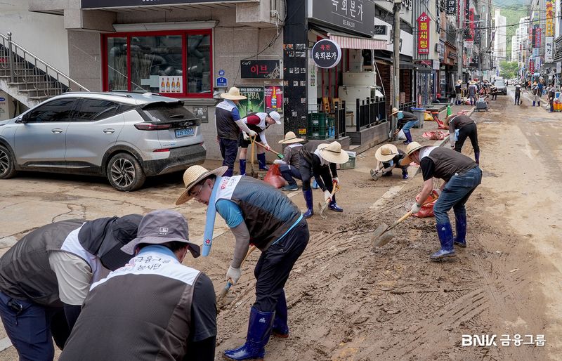 BNK금융그룹 임직원들이 19일 거제시 장평동과 고현동 일대에서 침수 피해를 입은 상가와 주택 등의 토사와 폐기물을 정리하고 있다. BNK금융그룹 제공