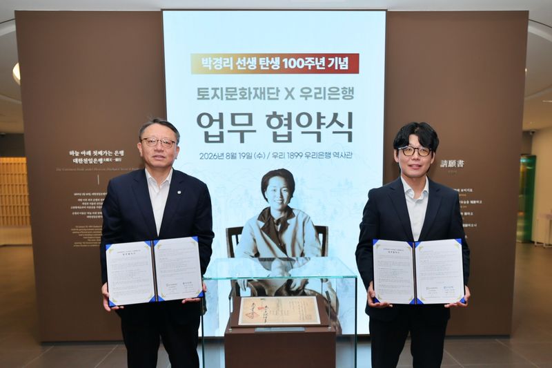 정진완 우리은행장(왼쪽)과 김세희 토지문화재단 이사장이 19일 서울 중구 우리은행 본점에 위치한 우리은행 역사관 '우리1899'에서 기념촬영을 하고 있다. 우리은행 제공