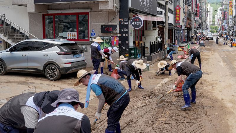 BNK금융그룹 임직원이 19일 거제시 장평동과 고현동 일대에서 침수 피해를 입은 상가와 주택 등의 토사와 폐기물을 정리하고 있다. BNK금융그룹 제공