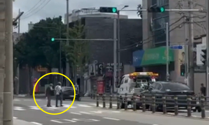 대구 동구 반야월에서 한 배달기사가 거동이 불편한 노인과 함께 횡단보도를 건너고 있다./사진=온라인 커뮤니티 '보배드림'