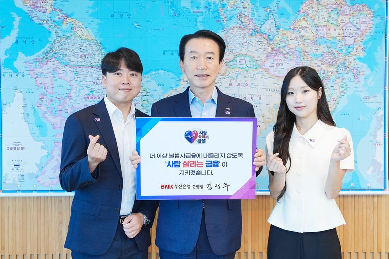 김성주 부산은행장(가운데)과 직원들이 20일 서민금융진흥원에서 시작한 '사람 살리는 금융' 릴레이 캠페인에 참여해 기념사진을 촬영하고 있다. 부산은행 제공