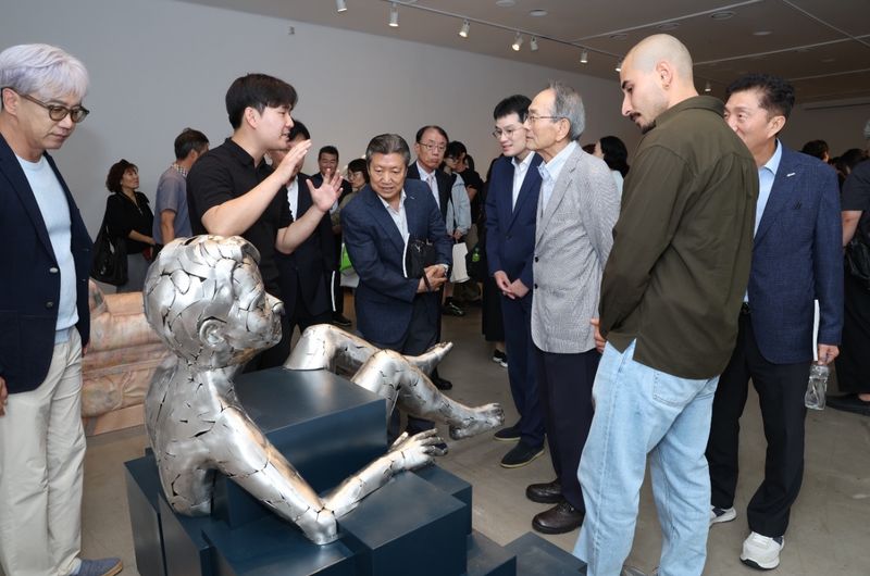 세계청소년문화재단 관계자들이 '2026 대교국제조형심포지엄' 참여 작가에게 작품 설명을 듣고 있다. 대교 제공