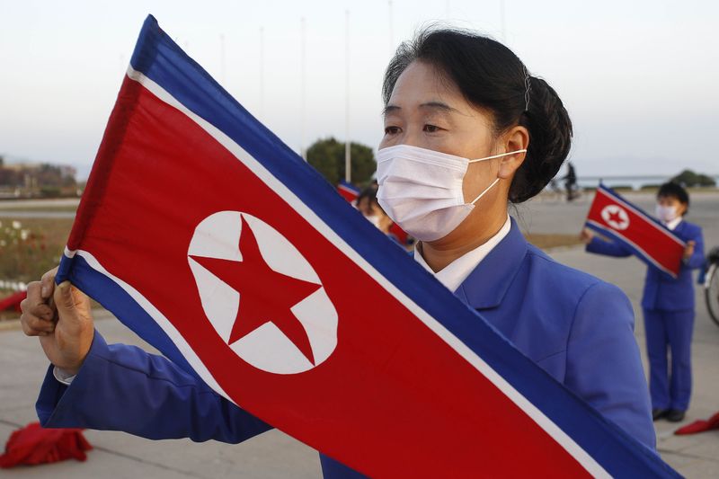 지난 2020년 10월 28일 북한 강원도 원산의 해안광장 앞에서 인공기를 든 원산시 여성노동조합원들이 출근 시간대 노동자들을 격려하기 위한 선동 활동을 하고 있는 모습. 뉴시스