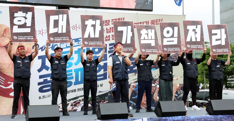 지난 21일 오후 서울 서초구 양재동 현대차그룹 본사 앞에서 열린 금속노조 자동차업종 공동파업 대회에서 노조원들이 현대차가 책임져라는 피켓을 들고 있다. 뉴시스 제공