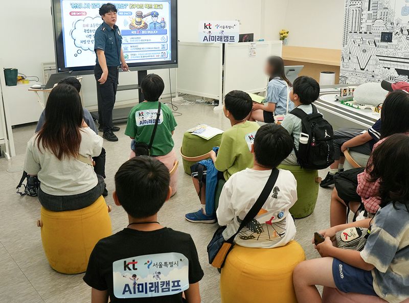 KT가 지난 22일 서울 도봉구 서울로봇인공지능과학관에서 초등학생 100명을 대상으로 개최한 'KT-서울시와 함께하는 AI 미래 캠프'에서 참가 학생들이 서울도봉경찰서 소속 경찰관으로부터 AI 범죄예방에 대한 교육을 받고 있다. KT 제공