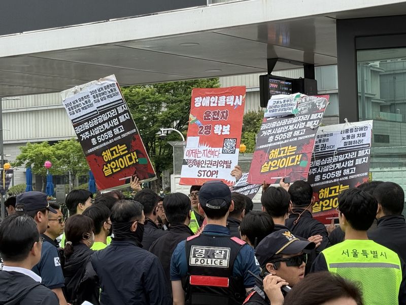 지난 5월 '감사의 정원' 개장식이 열린 광화문광장 한 켠에서 장애인 단체가 일자리·복지를 요구하는 시위를 벌이고 있다. 사진=이창훈 기자