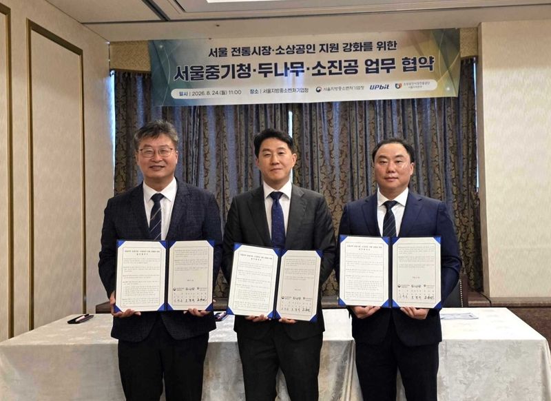 24일 정부과천청사 서울지방중소벤처기업청에서 김우순 서울지방중소벤처기업청 청장(왼쪽부터), 오경석 두나무 대표, 조용민 소상공인시장진흥공단 서울지역본부장이 업무협약(MOU)을 맺고 있다. 두나무 제공