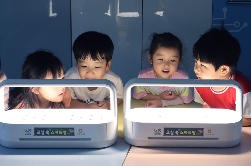 어린이들이 'LG 틔운 미니'에 심은 씨앗의 발아 과정을 살펴보고 있다. LG전자 제공
