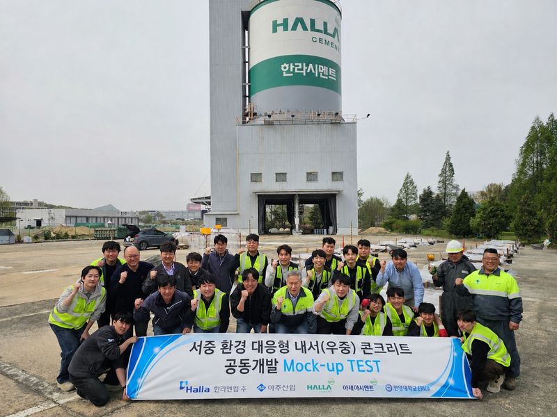 한라시멘트와 아세아시멘트, 한라엔컴, 아주산업 관계자들이 지난 4월 '서중 환경 대응형 콘크리트 제조기술'에 대한 현장 모사시험을 마치고 기념촬영을 하고 있다. 한라시멘트 제공