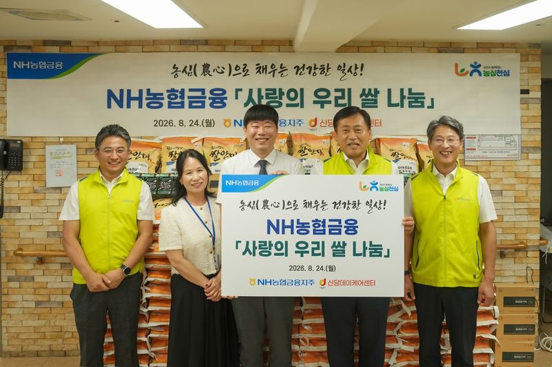 NH농협금융 박성헌 경영지원부장(오른쪽부터), 황종연 전략기획부문 부사장, 김무현 신당데이케어센터장이 서울 중구 소재 신당데이케어센터에서 '사랑의 우리쌀 나눔'을 기념해 사진 촬영을 하고 있다. 농협금융 제공