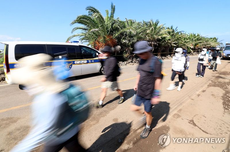 시신발견 장소 옆 지나는 도보여행자들 (출처=연합뉴스)