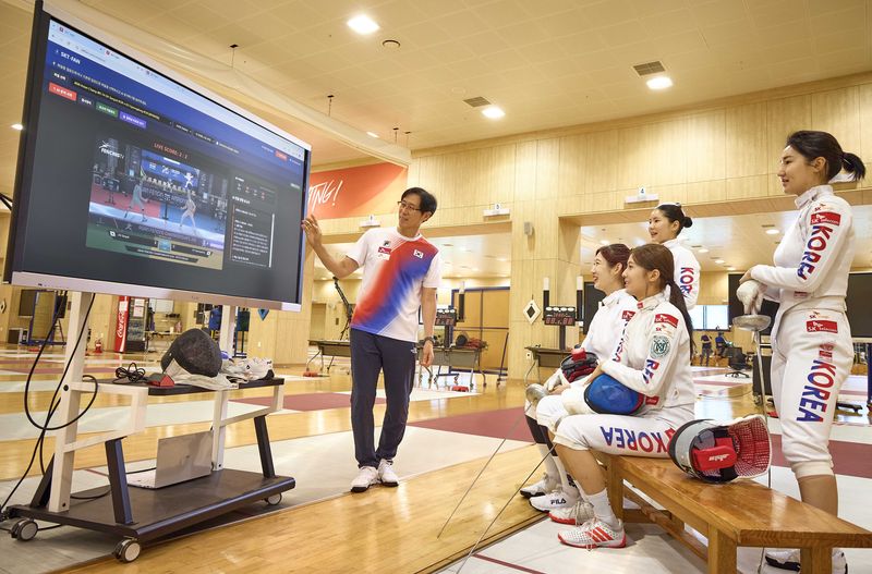 여자 펜싱 에페 국가대표팀 선수들과 함재만 코치가 SK텔레콤 펜싱 AI 전력분석 시스템 SKT-FAN을 활용해 전력 분석을 하고 있다. SK텔레콤 제공
