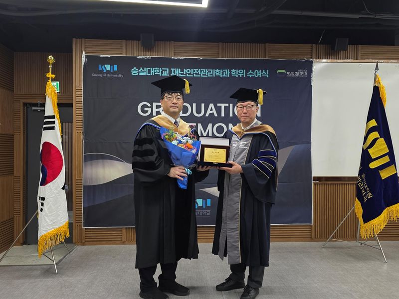 숭실대 대학원 재난안전관리학과 학위 수여식에서 초국가 범죄 대응 재외국민보호 분야 국내 1호 박사학위를 받은 박준석 주홍콩총영사관 선임 분석관(왼쪽)이 정종수 주임교수와 기념 촬영을 하고 있다. 숭실대 제공