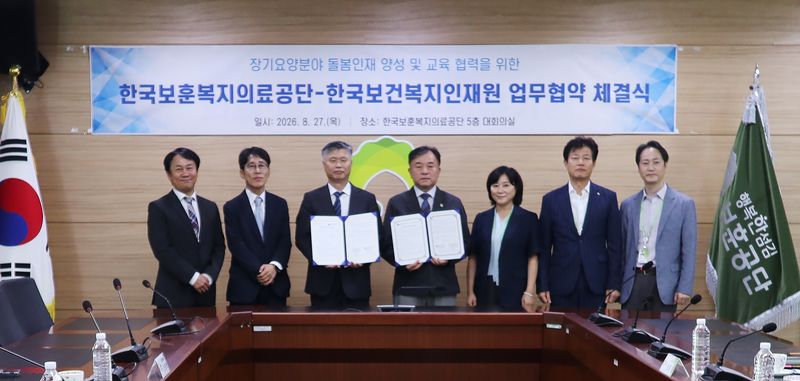 27일 한국보훈복지의료공단 본사에서 열린 업무협약식에서 박찬호 한국보훈복지의료공단 이사장 직무대행(오른쪽에서 네 번째)과 은민수 한국보건복지인재원장(왼쪽에서 세 번째)이 서명한 협약서를 들고 있다. 한국보훈복지의료공단 제공