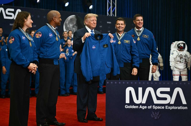 도널드 트럼프(가운데) 미국 대통령이 28일(현지시간) 텍사스주 휴스턴 미 항공우주국(NASA) 린든 B 존슨 우주센터에서 '아르테미스 2호' 승무원들로부터 재킷을 선물받은 뒤 기뻐하고 있다. 트럼프 대통령은 이날 행정명령을 통해 '우주군 사관학교' 설립에 착수했다. AFP 연합