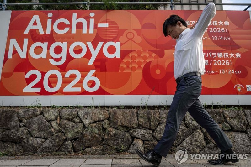 아시안게임 홍보 간판을 지나가는 나고야 시민 (출처=연합뉴스)