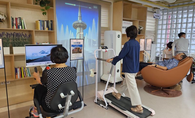 부산 에이지테크 상설 전시·체험공간 'AI 백세마루'에서 어르신들이 AI 기반 운동, 재활, 인지, 정서 제품을 체험한 뒤 에이지테크 앵커랩 공식 후원사인 세라젬이 조성한 후원존에서 휴식을 취하고 있다. 부산정보산업진흥원 제공