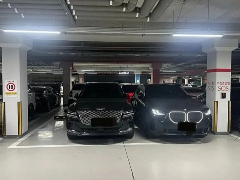 지하주차장에서 검은색 SUV 두 대가 문을 열기 어려울 정도로 바짝 붙어 주차돼 있다. 작성자 A씨는 상대 차주가 항의의 표시로 자신의 차량 조수석 쪽에 일부러 붙여 세웠다고 주장했다. /사진=보배드림