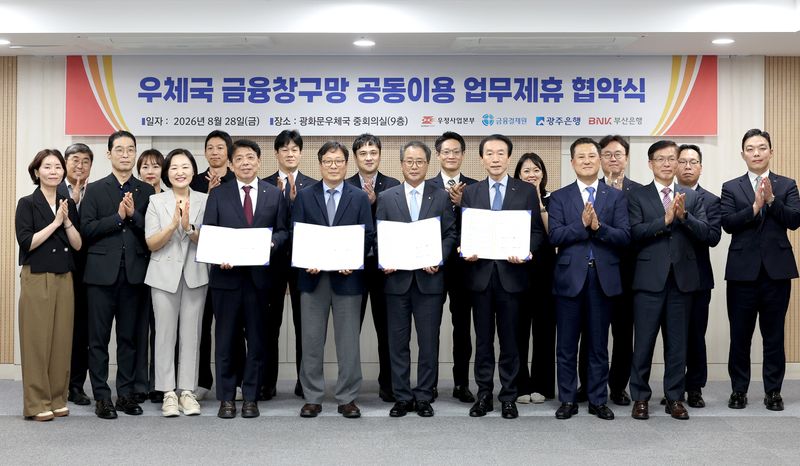 광주은행 정일선 은행장(앞줄 왼쪽 네번째부터), 우정사업본부 박인환 본부장, 금융결제원 채병득 원장, BNK부산은행 김성주 은행장이 업무협약서를 들고 포즈를 취하고 있다. 부산은행 제공