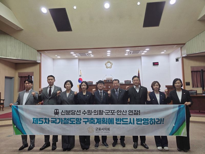 [군포=뉴시스] 군포시의회 의원들이 1일 본회의장에서 '신분당선 수원·의왕·군포·안산 연장선 제5차 국가철도망 구축계획 반영 촉구 결의안'을 채택하고 현수막을 내걸고 구호를 외치고 있다. (사진=군포시의회 제공).2026.09.01. photo@newsis.com