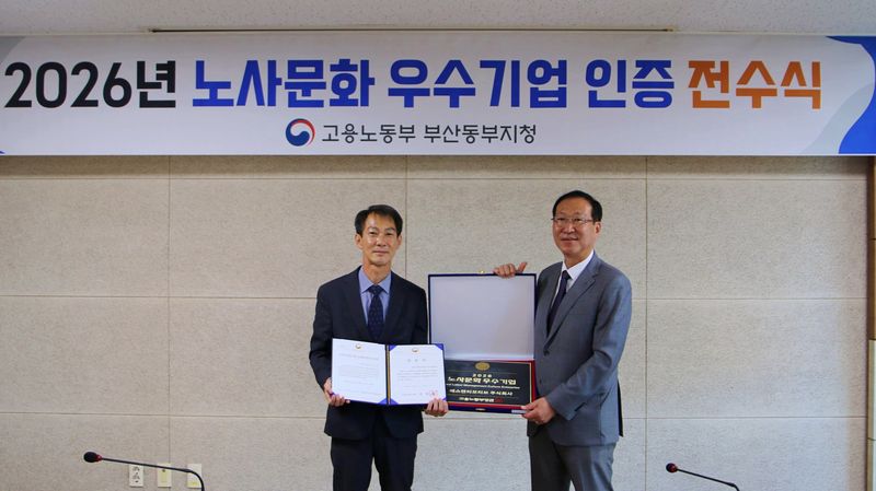 SNT모티브 권형순 대표이사(오른쪽)가 김학수 고용노동부 부산동부지청장에게 인증서를 받은 후 기념촬영을 하고 있다. SNT모티브 제공