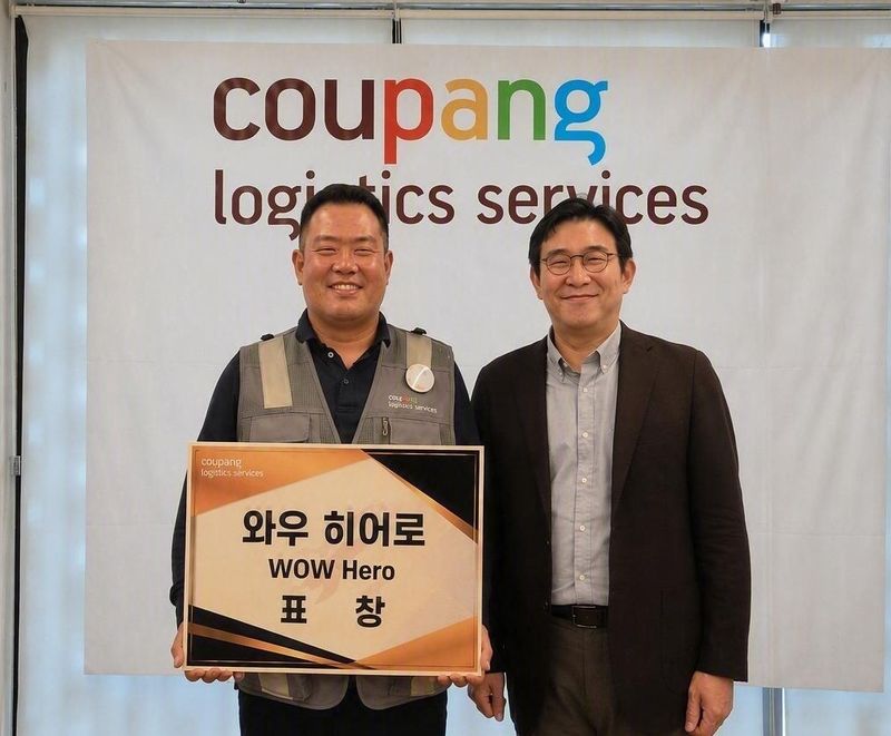 지난달 26일 서울 성동구 성동1캠프에서 열린 시상식에서 와우 히어로로 선정된 쿠팡친구 유태선씨와 홍용준 쿠팡로지스틱스서비스(CLS) 대표이사(왼쪽부터)가 기념촬영을 하고 있다. CLS 제공