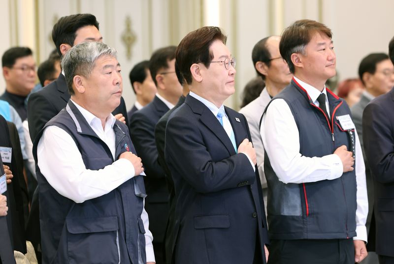 이재명 대통령이 지난 5월 1일 청와대 영빈관에서 열린 2026 노동절 기념식에서 국민의례를 하고 있다. 왼쪽부터 김동명 한국노총 위원장, 이 대통령, 양경수 민주노총 위원장. 뉴스1
