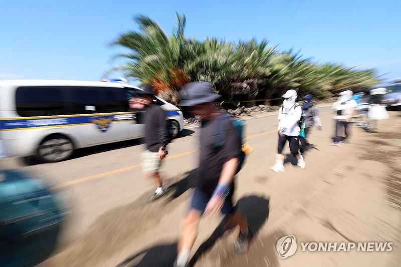 시신 발견 장소 옆 지나는 도보 여행자들 (출처=연합뉴스)