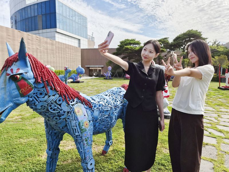 롯데백화점 광복점 옥상공원에 설치된 정크아트 작품 앞에서 관람객들이 셀카를 찍으며 즐거운 시간을 보내고 있다. 롯데백화점 제공