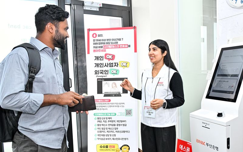 BNK부산은행 영업점에 배치된 외국인 서포터즈(오른쪽)가 외국인 고객에게 금융 관련 업무를 설명하고 있다. 부산은행 제공
