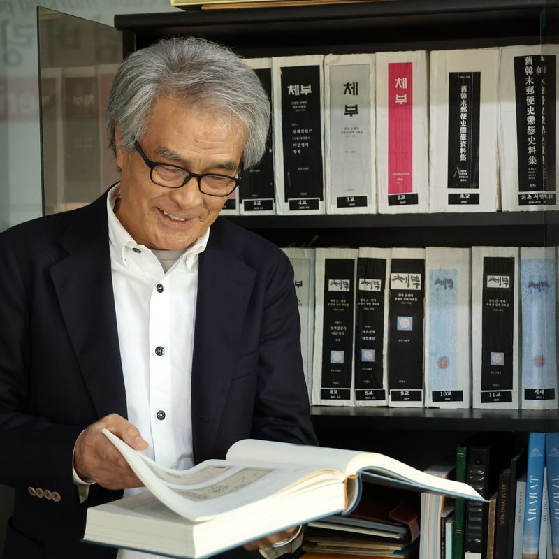 '체부' 시리즈 세 번째 책을 펴낸 나봉주 반도엠피에스 대표가 자신의 저서를 넘겨보며 환하게 웃고 있다. 사진=서동일 기자