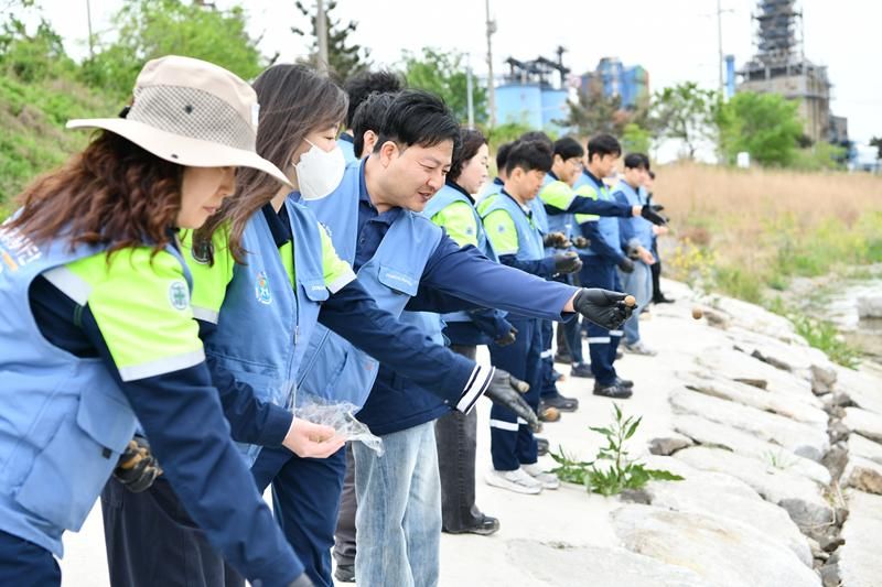 포스코퓨처엠 직원과 가족들이 지난 4월 '퓨처엠 Nature Guard Day' 봉사활동에 참여해 씨드볼을 만들어 포항시 남구 냉천에 던지고 있다.