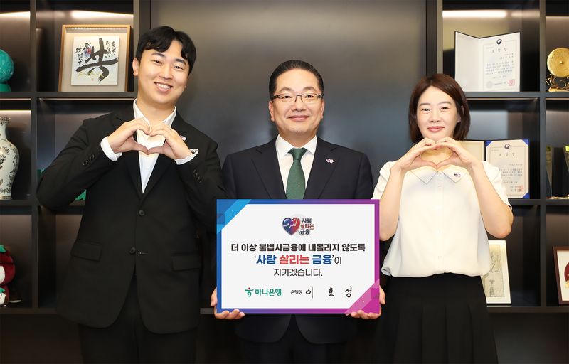 이호성 하나은행장(가운데)이 서울 중구 하나은행 을지로 본점에서 사람 살리는 금융 릴레이 캠페인에 동참하기 위해 '더 이상 불법사금융에 내몰리지 않도록 사람 살리는 금융이 지키겠습니다'라는 메시지를 담은 피켓을 들고 사진촬영을 하고 있다. 하나은행 제공