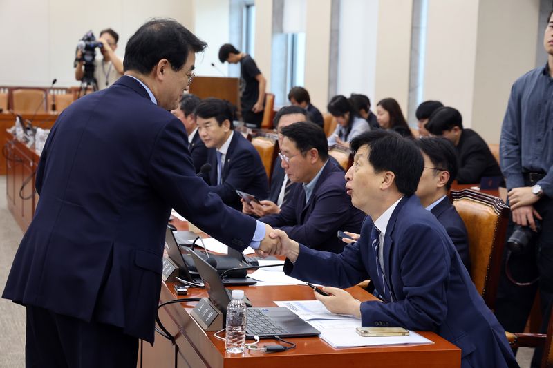 8일 오후 서울 여의도 국회에서 열린 재정경제기획위원회 전체회의에서 오기형 여당 간사와 배준영 야당 간사가 악수를 나누고 있다. 뉴스1