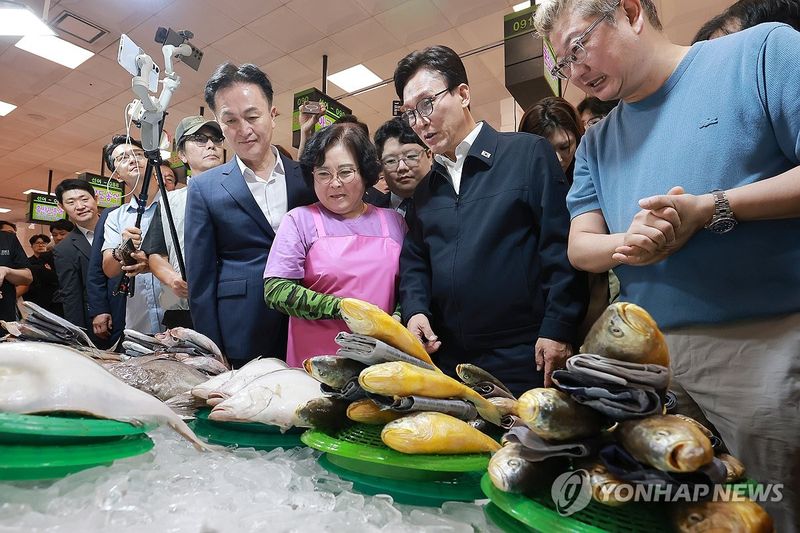 김민석 더불어민주당 대표(오른쪽 두번째)가 8일 서울 노량진수산시장을 방문, 생선가게를 둘러보고 있다. 연합뉴스
