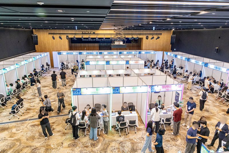 8일 서울시립대 100주년기념관에서 열린 취업박람회 '2026 UOS 잡 페스티벌'에서 구직 청년들이 기업 부스를 찾아 상담을 받고 있다. 서울시립대 제공