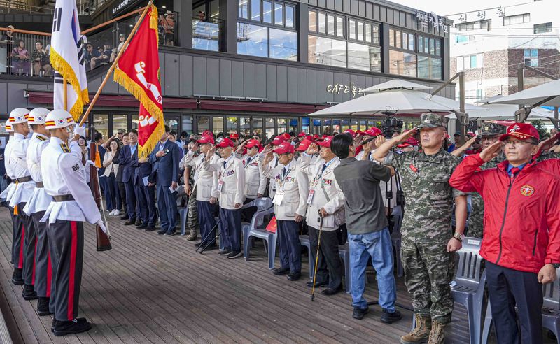 지난 5일 서울 서대문구 홍제천 폭포공원에서 열린 연희고지전투 전승기념 및 추모식에서 참전용사를 비롯한 참석자들이 국기에 경례하고 있다. 해병대사령부 제공