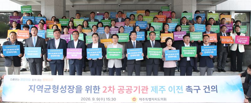 송영훈 제주특별자치도의회 의장을 비롯한 도의원과 사무처 직원들이 9일 오후 제주도의회 의사당 앞에서 ‘지역균형성장을 위한 2차 공공기관 제주 이전 촉구 건의’를 발표한 뒤 한국마사회·한국공항공사 등 유치 희망기관이 적힌 손팻말을 들고 구호를 외치고 있다. 사진=제주특별자치도의회 제공