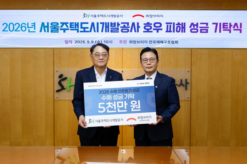 황상하 서울주택도시공사(SH) 사장(왼쪽)과 신훈 희망브리지 사무총장이 9일 SH에서 열린 집중호우 피해지역 복구 성금 기탁식에서 기념촬영을 하고 있다. SH 제공