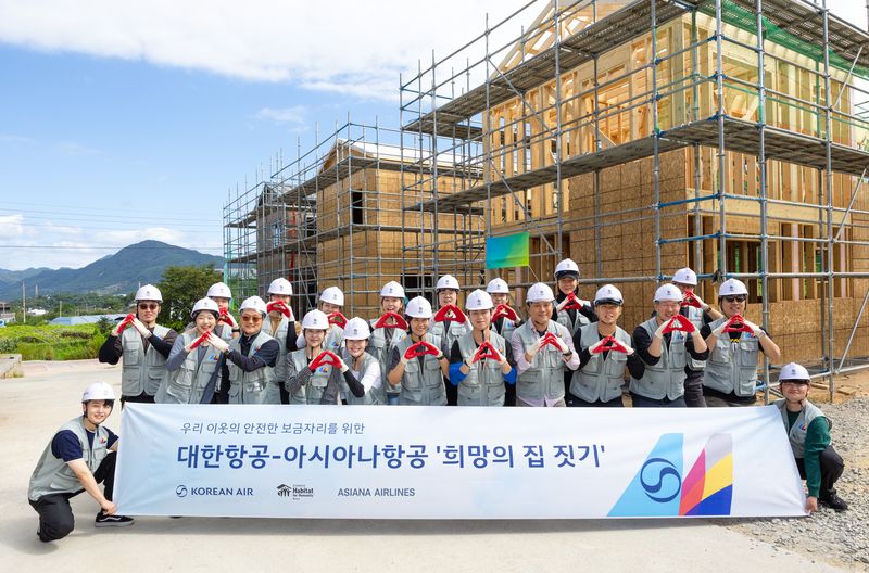 한국해비타트 '희망의 집 짓기' 봉사활동에 참여한 대한항공, 아시아나항공 임직원들이 기념사진을 촬영하고 있다. 대한항공 제공
