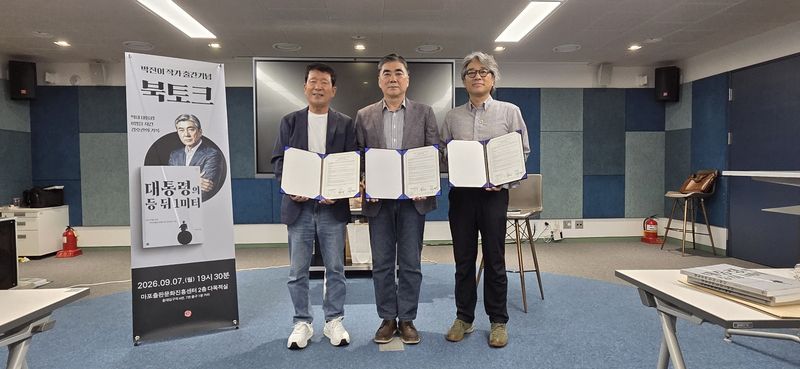 '대통령의 등 뒤 1미터' 인세 일부를 김영식세자녀출산지원재단 출산축하금으로 기부하기로 하는 협약식에 참석한 박진이 작가(가운데)와 김영식 이사장(왼쪽) 등이 포즈를 취하고 있다. 김영식세자녀출산지원재단 제공
