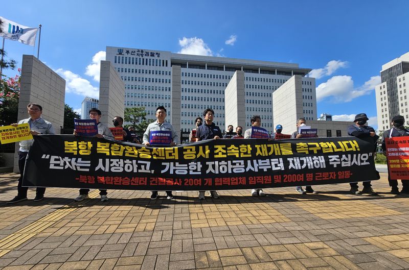 부산 북항 복합환승센터 건설사업 시행사 협력업체 6개사 임직원 30여명이 10일 오후 부산지방검찰청 앞에서 집회를 열고 법원에 조속한 공사 재개 결정을 내려줄 것을 호소하고 있다. 사진=변옥환 기자