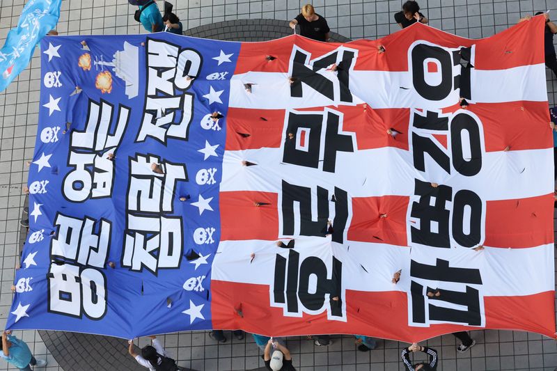 지난 12일 대전 중구 으능정이거리에서 열린 '호르무즈 파병 반대' 집회에서 참가자들이 '명분 없는 침략전쟁, 호르무즈 파병 강요'가 적힌 대형 현수막을 찢는 퍼포먼스를 벌이고 있다. 연합뉴스
