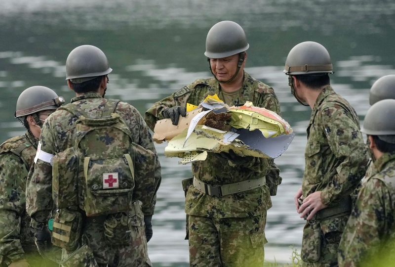 [이누야마=AP/뉴시스]일본 육상자위대가 대학 교수와 비정부기구(NGO) 관계자 등 민간인의 사상과 성적 취향, 금전 상황 등 개인정보를 수집해온 것으로 전해졌다. 사진은 2025년 5월15일 일본 중부 아이치현 이누야마의 한 저수지에서 일본 자위대원이 전날 추락한 항공자위대 훈련기의 잔해로 추정되는 물체를 들고 있는 모습. 사진은 해당기사와 관련없음.