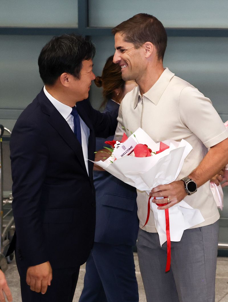 로베르토 모레노 대한민국 남자 축구 대표팀 임시 감독이 13일 인천국제공항 1터미널을 통해 입국하며 대한축구협회 관계자에게 꽃다발을 받고 있다. 2026.9.13 ⓒ 뉴스1 최지환 기자