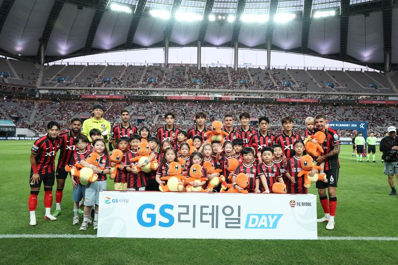 지난 5일 GS리테일 브랜드 데이 행사에 참석한 임직원 자녀들이 경기에 앞서 FC서울 선수들과 기념 촬영을 하고 있다. GS리테일 제공